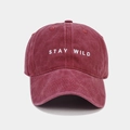Détail macro de la broderie 'STAY WILD' sur la casquette en coton délavé bordeaux - Bordeaux