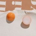 Macro view of orange and white round resin beads on white stone for DIY jewelry craft - Orange Round