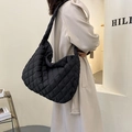 Detail of a large black quilted tote bag with diamond pattern and crossbody strap - Black