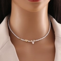 Minimalist beaded necklace with gold heart and letter V shell pendant worn by model - Letter V