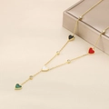 Détail du collier à cœurs dorés avec pendentifs colorés sur une boîte à bijoux - Coloré