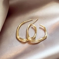 Elegant gold-tone irregular geometric wave-textured earrings on champagne satin - Gold Irregular Lava / Gold