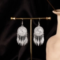 Dettaglio di orecchini etnici con nappe e intagli cavi su sfondo di seta nera elegante - Nappa Geometrica (E1116-1) / Argento