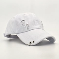 Détail de la casquette de baseball blanche en coton avec anneaux métalliques et déchirures - Blanc