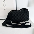 Detail of black knit popcorn bag showing 3D bubble texture and wide shoulder strap - Black
