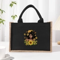 Black canvas and jute tote bag featuring a crown-wearing woman and sunflower print - Black Graphic 1