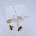Detailed close-up of a gold-plated bee pendant necklace with colorful zircons by a gift box - Gold Bee with Colorful Wings