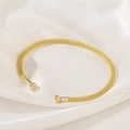 Macro detail of the woven mesh texture and golden finish on this stylish open cuff bracelet - Gold