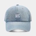 Detailed close-up of light blue denim baseball cap with white NYC embroidery and twill texture - Adjustable / Light Blue