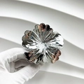 Détail d'une pince à cheveux fleur argentée tenue avec un gant blanc professionnel - Camélia / Argent