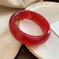 Détail d'un bracelet jonc en résine rouge translucide posé sur un plat en céramique - 104# Bracelet Large-Rouge Foncé