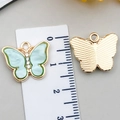 Pendentif papillon doré avec incrustation de nacre vert clair et strass sur règle - Bleu lac