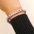 Macro detail of elastic ceramic bracelet with GRANDMA letter beads and blue floral patterns - GRANDMA Letter Style (A-1091)