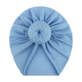 Detailed macro view of soft blue knitted baby turban hat with a knotted doughnut design - Blue