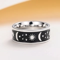 Detailed macro view of celestial star and moon patterns on a wide enamel unisex band - US 7 / Steel