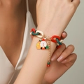 Kerstarmband met rood-groene ketting en de Kerstman-hanger op de pols gedragen - D1047 (Kerstman)