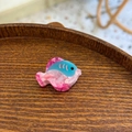 Détail de la pince à cheveux poisson en acétate rose et bleu sur plateau bois - Mini Poisson Tropical Rose Bleu