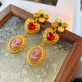 Dettaglio di orecchini vintage con fiori verdi, cuori rossi e pendenti cammeo rosa - Oro / Oro
