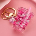 Detail of creative fruit tea keychain with liquid, dragon fruit slices and gold clasp - Purple Cup