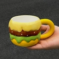 Mug creativo in ceramica a forma di hamburger con design colorato a strati tenuto in mano - Tazza Hamburger (Singola)