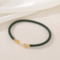 Detail of dark green braided rope bracelet with gold mushroom-shaped metal ends - Dark Green