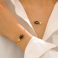 Set aus goldener Herzkette und Rugby-Armband an einer Frau, eleganter sportlicher Stil - Halskette Armband Set (Football)