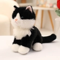 Süße schwarz-weiße Plüschkatze sitzend als Stofftier mit weichem Fell und blauen Augen - 20cm / Schwarze Katze