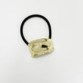 Dettaglio di un elastico per capelli nero con chiusura in metallo dorato lucido e curvo - Oro