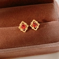 Dettaglio di orecchini a fiore vintage dorati con gemma rossa in una scatola regalo - Base Dorata Gemma Rossa (Perno in Argento) / Rosso