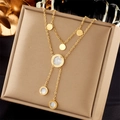 Detailed shot of double-layer gold necklace with shell pendants on premium beige jewelry box - Double Layer Round Shell Pendant Necklace