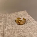 Golden bow heart ring with tiger eye stone and radial texture on a vintage open band - Wide Rice Grain Tiger Eye Ring
