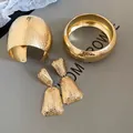 Goldenes Boho-Schmuckset mit strukturierten Armreifen und langen Hängeohrringen - 3-teiliges Set / Gold