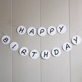 White macaron birthday banner with black Happy Birthday lettering on round cardstock - Round White Cartoon Birthday Banner