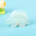 Handgeschnitzte Opal-Stegosaurus Kristall-Tierfigur auf hellblauem Hintergrund - Opalith