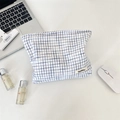 Macro view of blue checkered cotton makeup bag showing fabric texture and woven label - White With Blue Grid
