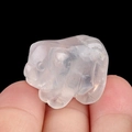 Mini hand-carved transparent natural crystal pig figurine held to show miniature scale - White Crystal