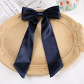 Navy blue satin bow hair clip with long streamers on a decorative beige oval tray - Duckbill Hair Clips / Navy Blue