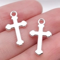 Set of two silver cross pendants for DIY jewelry making shown on finger for scale - 19x11mm (0.7g)