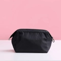 Waterproof black nylon cosmetic storage bag with silver zipper on a pink background - Black