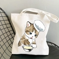 White canvas tote bag featuring a kawaii cat chef print on a metal chair - Chef Cat Eating Noodles