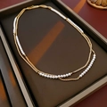 Detalle de collar de doble capa con cadena dorada y perlas blancas en soporte de joyas - Collar de perlas