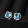 Detailed macro view of cushion-cut blue zircon stud earrings with silver halo setting - Aquamarine