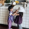 Detailed view of child wearing a white foldable straw sun hat for vacation and beach - White