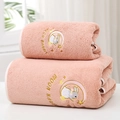Pink coral fleece bath towels featuring moon rabbit embroidery in a stack - Moon Rabbit Nude Pink