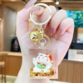 Maneki Neko acrylic keychain with golden glitter and bell held in hand - Lucky Cat Family - Waving / Individual Packaging