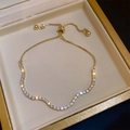 Close-up of a gold zircon pearl bracelet with an adjustable slider clasp in a jewelry box - Rhinestone Gold Wave Bracelet