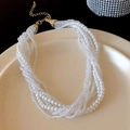 Multi-layer necklace featuring white faux pearls and faceted crystals with golden clasp - White