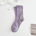 Weiche violette Baumwollsocken in minimalistischer Flachlage auf weißem Hintergrund - Hellviolett