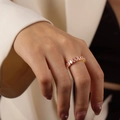 Minimalist gold ring featuring a row of oval pink zircons on a model's hand - Type B Pink