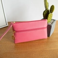 Pink pebbled leather double zipper pouch with heart-shaped gold puller on a wooden desk - Rose Red